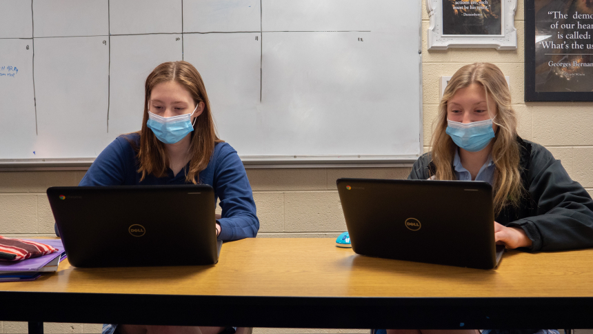 Two female Lansing Catholic Students work on their Chromebooks in class
